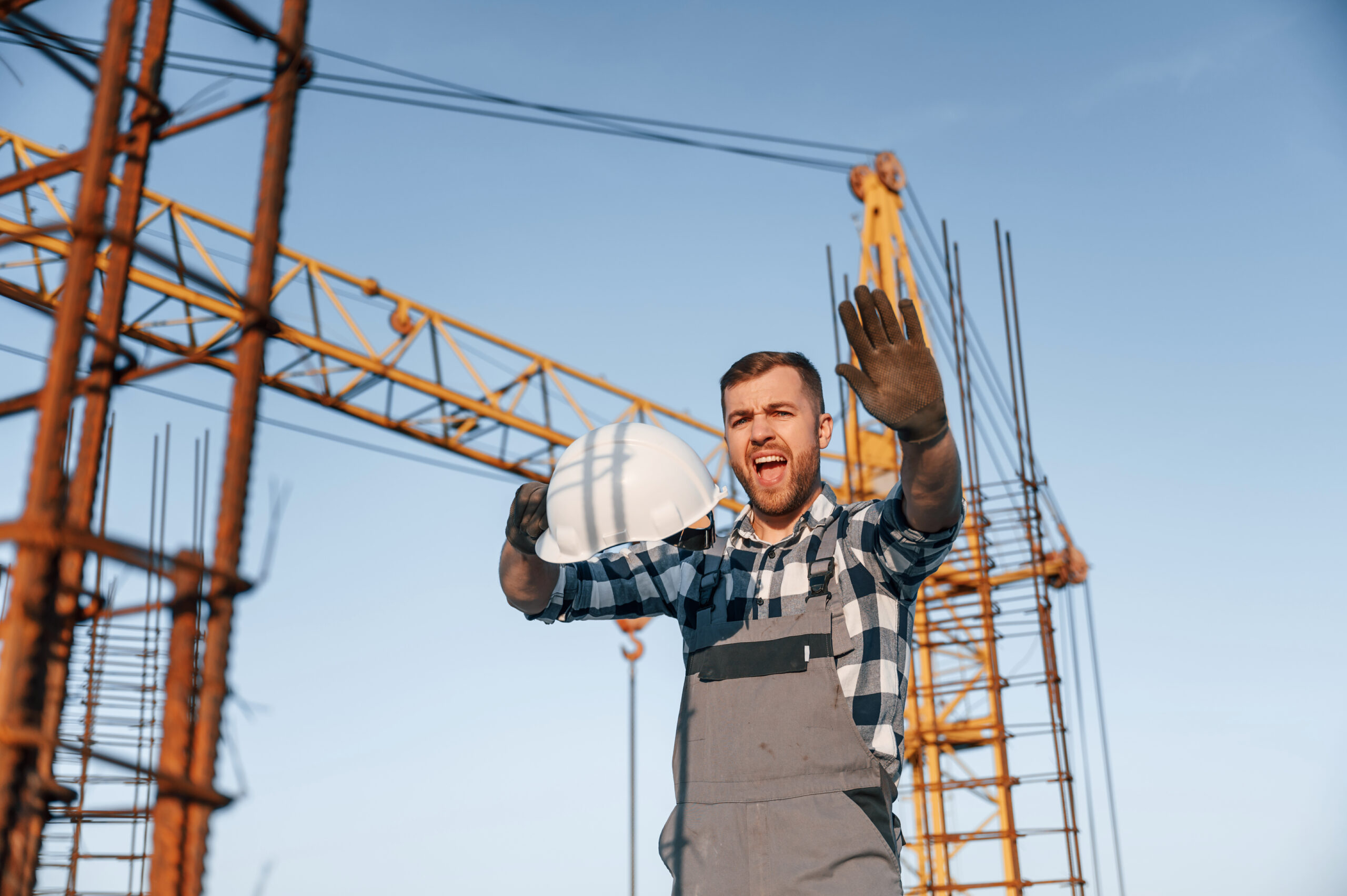 Wütender Mann arbeitet tagsüber auf der Baustelle
