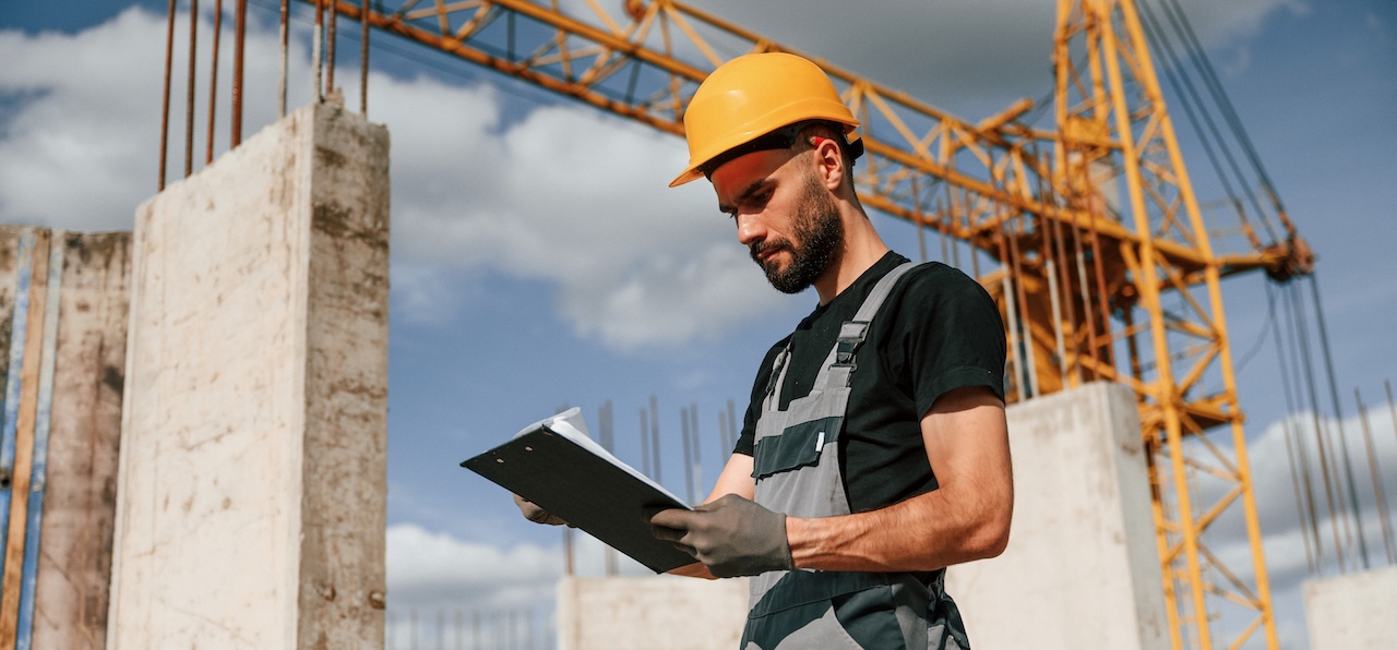 Arbeiter auf einem Bau mit Bauplänen - Bewertung mangelhafter Leistungsverzeichnisse